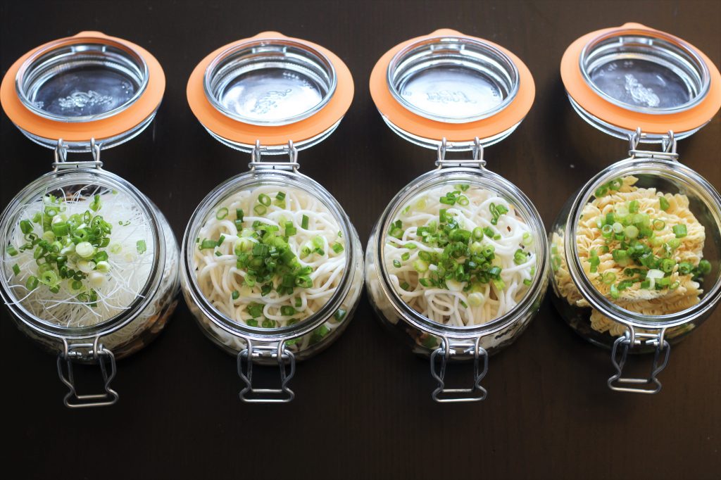 The four glass jars with various noodles added.
