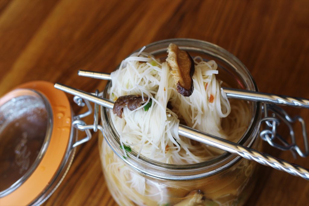 A close up of the prepared noodle jar with noodles, jerky, and shiitakes.