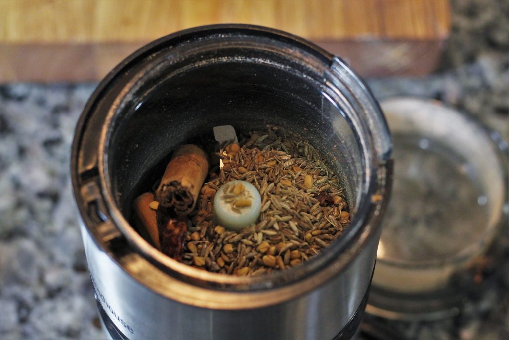 the ingredients of the curry powder in a spice grinder