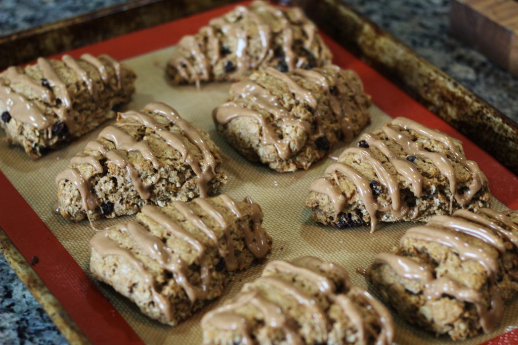 The scones on the baking tray with the glazed drizzled on. 