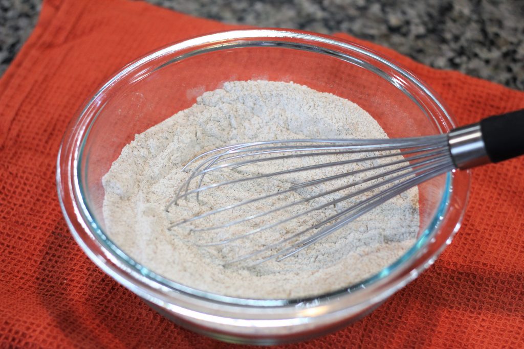The flours, sugar, salt, baking soda and powder combined in a bowl. 