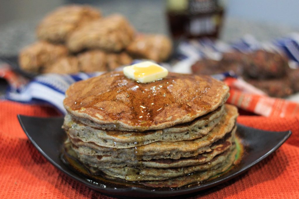 A stack of pancakes with butter and maple syrup.